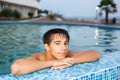 Teenager relaxing near ledge in pool open-air