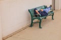 Teenager Resting on a Sidewalk Bench