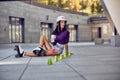 Teenager rollerblading sitting on street and drink coffee