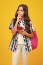 Teenager school student girl with mobile phone on isolated background. Thinking pensive clever teenager girl. Royalty Free Stock Photo