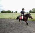 Teenager seen enjoying himself at the gallop with a pony.