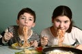 Teenager siblings brother and sister eating spaghetti