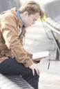 Teenager sitting on bench reading Bible