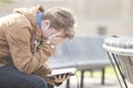 Teenager sitting on bench reading Bible and praying