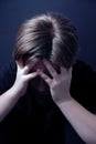 Teenager sitting in a closed posture experiencing depression during COVID-19 lockdown