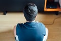 Teenager sitting on the floor at home playing a video game on the console Royalty Free Stock Photo