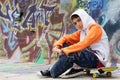 Teenager sitting near a graffiti wall Royalty Free Stock Photo