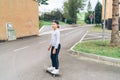 Teenager skateboarder boy in baseball cap riding a skateboard on asphalt street road. Youth generation Freetime spending and Royalty Free Stock Photo