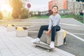 Teenager skateboarder boy portrait in a baseball cap with old skateboard on the city street. Youth generation Free time spending