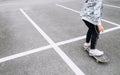 Teenager skateboarder boy with a skateboard on asphalt playground doing tricks. Youth generation Freetime spending concept image Royalty Free Stock Photo