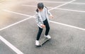 Teenager skateboarder boy with a skateboard on asphalt playground doing tricks. Youth generation Freetime spending concept image