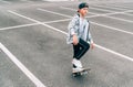 Teenager skateboarder boy with a skateboard on asphalt playground doing tricks. Youth generation outdoor Freetime spending concept Royalty Free Stock Photo