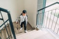 Teenager skateboarder boy with a skateboard going up by staircase home. Youth generation Freetime spending concept image Royalty Free Stock Photo