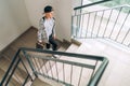 Teenager skateboarder boy with a skateboard going up by staircase home. Youth generation Freetime spending concept image Royalty Free Stock Photo