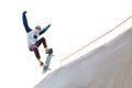 The teenager skateboarder in the cap does a trick with a jump on the ramp in the skatepark. Isolated skater and ramp on