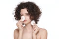 Teenager skincare. Beautiful teenage girl with gorgeous curly hair playing with make up removing cotton pads.