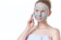 Teenager skincare concept. Young teen girl with dried clay facial mask making phone call