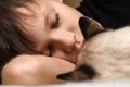 A teenager is sleeping on the bed with an animal cat Royalty Free Stock Photo