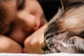 A teenager is sleeping on the bed with an animal cat Royalty Free Stock Photo