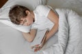 The teenager sleeps in bed. He fell asleep with the book Royalty Free Stock Photo