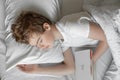 The teenager sleeps in bed. He fell asleep with the book Royalty Free Stock Photo