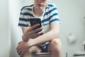 Teenager with a smartphone on toilet Royalty Free Stock Photo