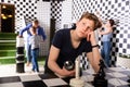 Teenager solving conundrum in quest room stylized under chessboard