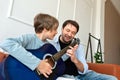 Teenager son learning to playing acoustic guitar with father support. Happy single parent family relations, loving father teaching Royalty Free Stock Photo