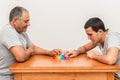 Teenager son and senior father sitting in home and playing with flexible toy the poppit fidget.