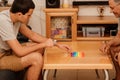 Teenager son and senior father sitting in home and playing with flexible toy the poppit fidget.