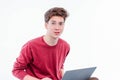 Teenager student with funny face working at laptop on white background Royalty Free Stock Photo