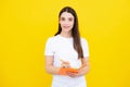 Teenager student girl isolated on yellow background. Cheerful young woman student in shirt hold notebooks showing. High Royalty Free Stock Photo