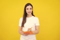 Teenager student girl  on yellow background. Cheerful young woman student in shirt hold notebooks showing. High Royalty Free Stock Photo