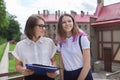 Teenager student girl talking with teacher, woman with clipboard