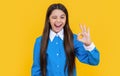 teenager student has winking face. all is ok. teenager school girl in uniform show ok. portrait of teenager girl. girl