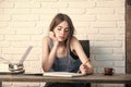 Teenager student in jean pinafore on white brick wall