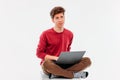 Teenager student thinking and working at laptop on white background Royalty Free Stock Photo