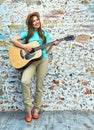 Teenager style portrait of young woman playing acoustic guitar Royalty Free Stock Photo