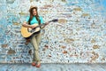 Teenager style portrait of young woman playing acoustic guitar Royalty Free Stock Photo