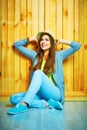 Teenager style young woman sitting on a floor. Looking up. Royalty Free Stock Photo