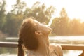 Teenager summertime,young girl in the park drinks water,smiling on a bench relaxes on a sunny summer day Royalty Free Stock Photo