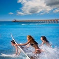 Teenager surfers running jumping on surfboards