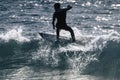 Teenager surfing at the wave in tenerife playa de las americas - white and black wetsuits and beautiful and small wave