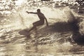 Teenager surfing at the wave in tenerife playa de las americas - white and black wetsuits and beautiful and small wave