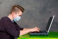 Teenager with surgical mask protect computer from virus