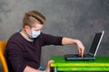 Teenager with surgical mask protect computer from virus