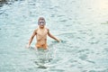 Teenager in swimming goggles enjoys summer holidays on beach Royalty Free Stock Photo