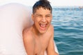 Teenager swims in the sea with big splashes. Cute boy enjoys swimming in the ocean. Royalty Free Stock Photo