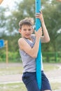 A teenager in a T-shirt climbs on a gymnastic pole Royalty Free Stock Photo