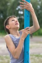 A teenager in a T-shirt climbs on a gymnastic pole Royalty Free Stock Photo